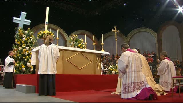 Fiéis ajoelhados em adoração eucarística